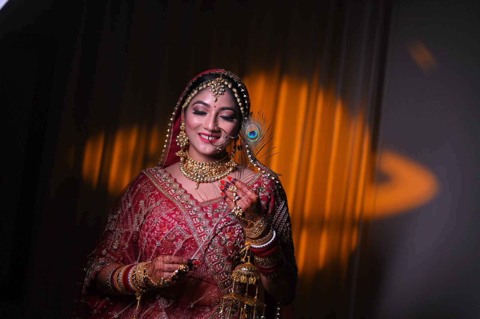 ZigpicS signature bridal portrait — bride in red lehenga with gold jewellery, Muzaffarpur
